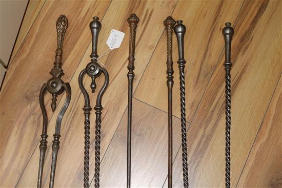 A set of three George III steel and brass fire irons and a set of three steel fire irons